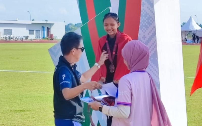 Wilna Selvi di podium penggalungan medali 17th SEA U18 Athletics Championships 2025 di Stadion Madya Atletik Sena, Batang Kuis, Deli Serdang, Sumatera Utara, Senin (17/11/2025). Wilna meraih medali perak nomoe 3.000 meter putri. (Foto Istimewa)